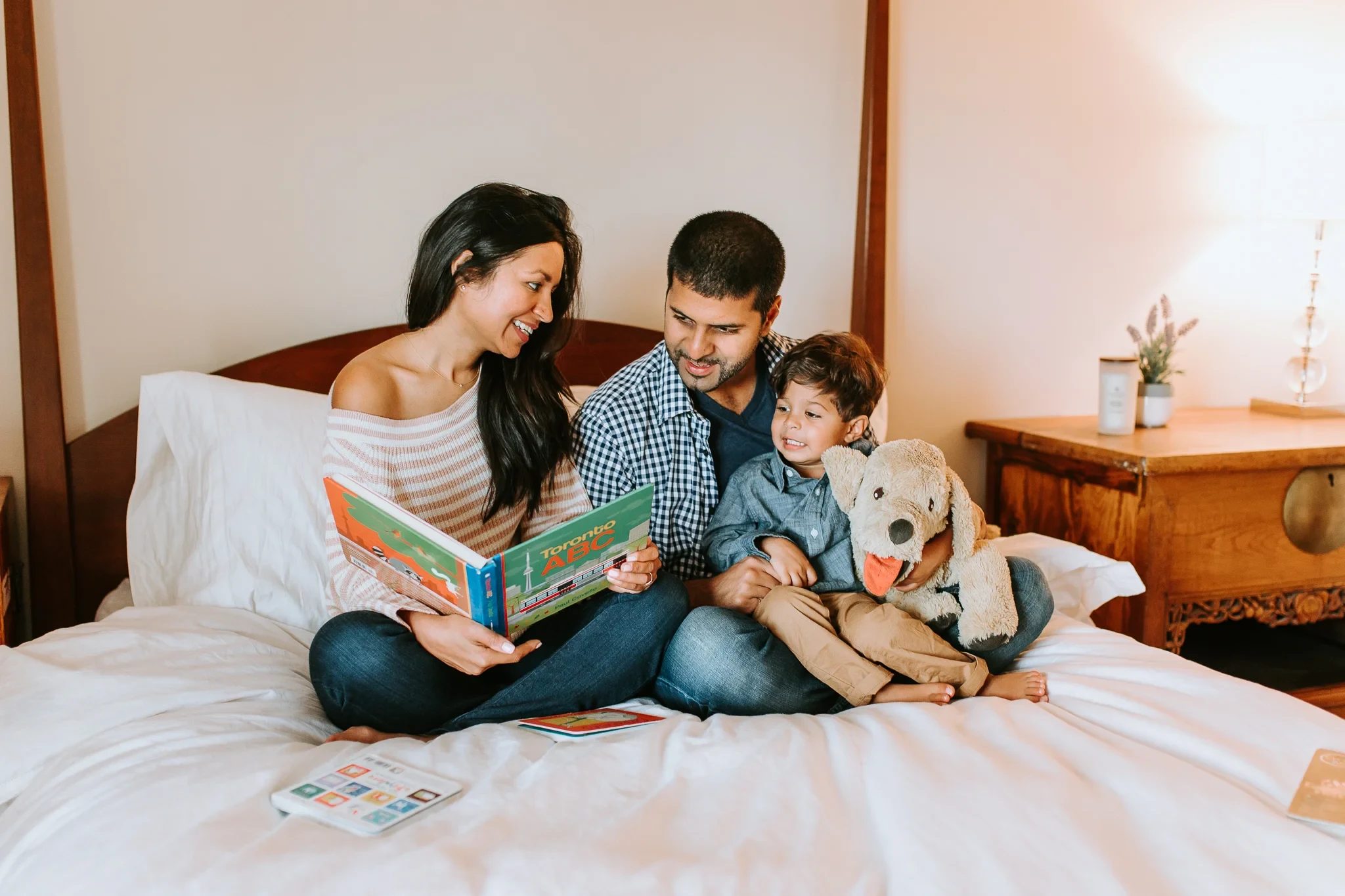 Family reads a picture book together on a bed