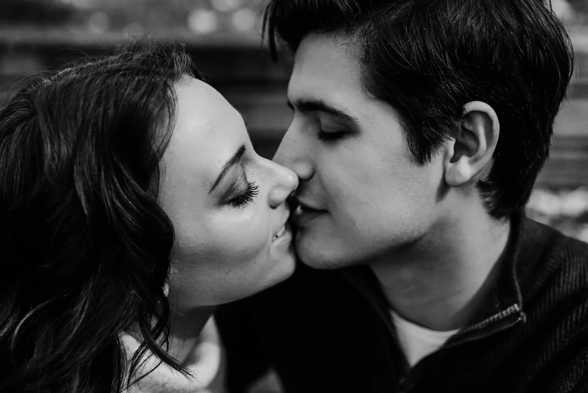 Black-and-white close-up of two adults touching noses