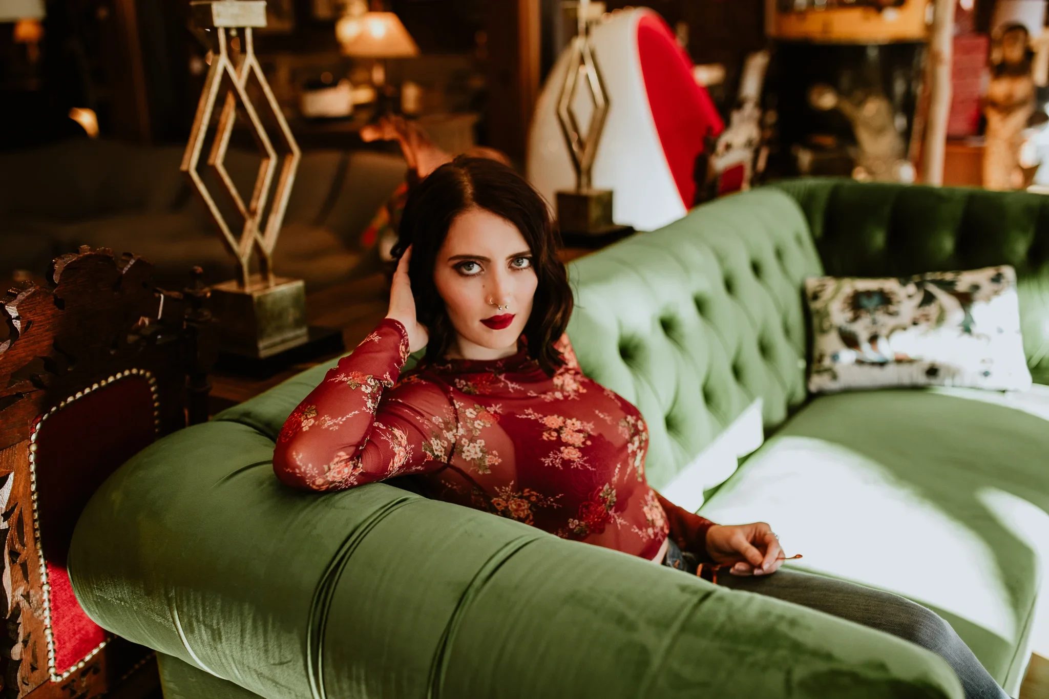 Woman in red lace reclines on a pale green sofa