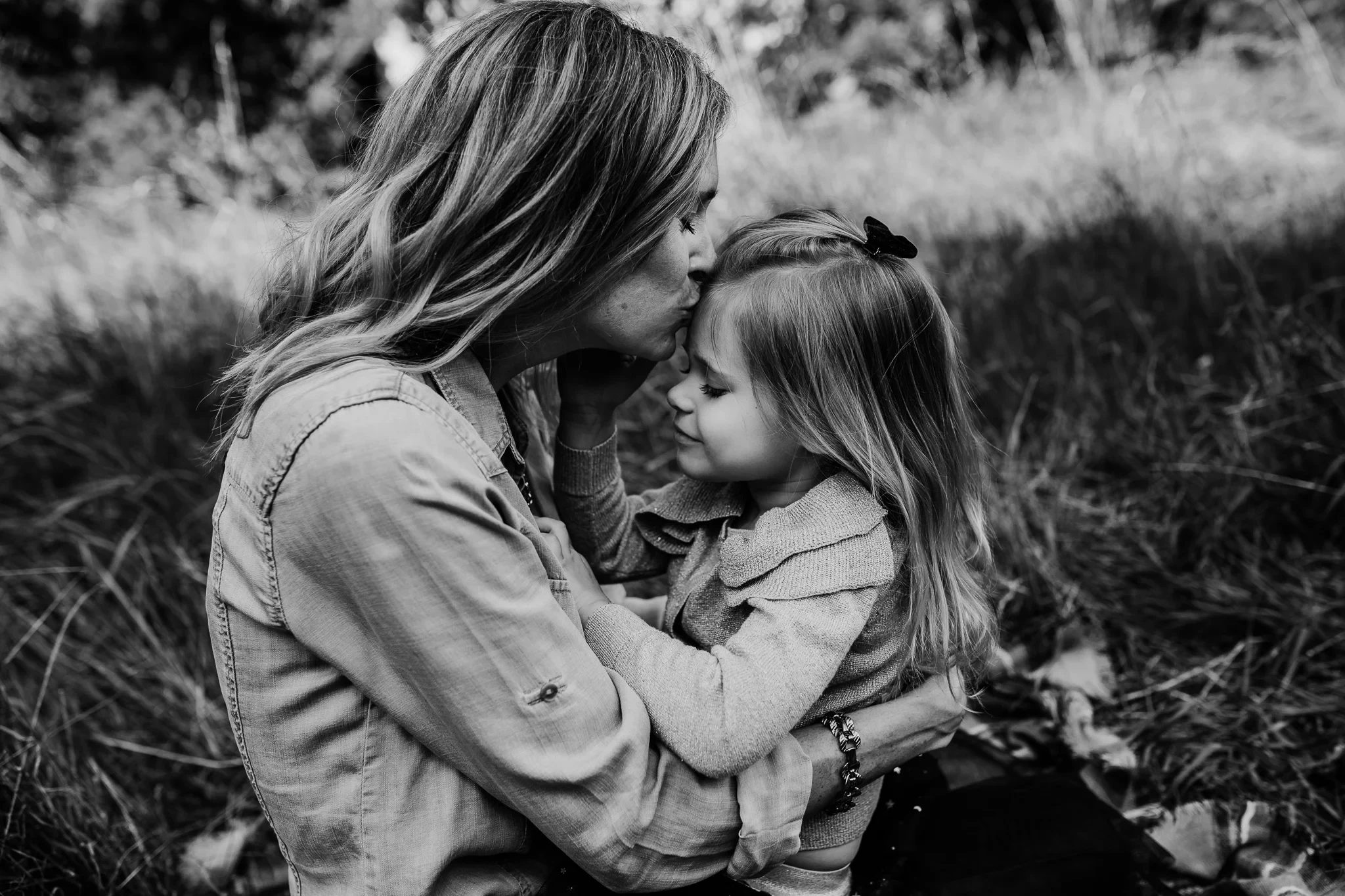 Black-and-white photograph of a woman touching foreheads with a child