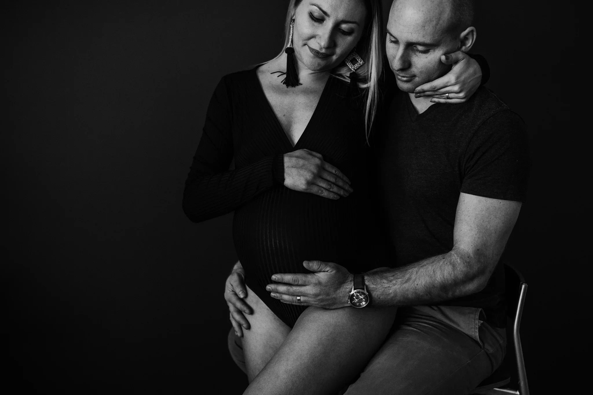 Black-and-white seated portrait of two adults with their hands resting together