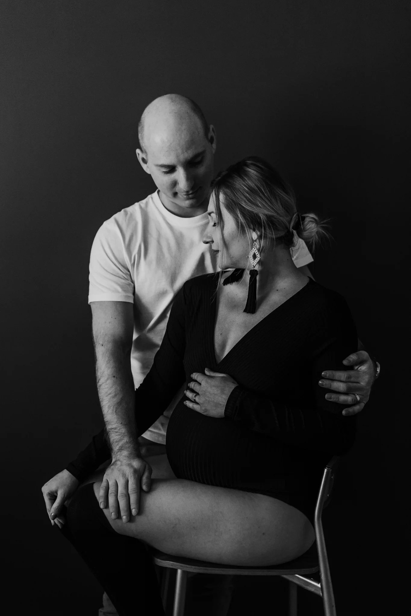 Black-and-white seated portrait of two adults against a dark background